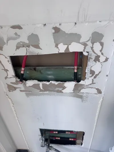 Wall opened to re-run the hot and cold lines in PEX through the noggins, the old wall tap outlets removed