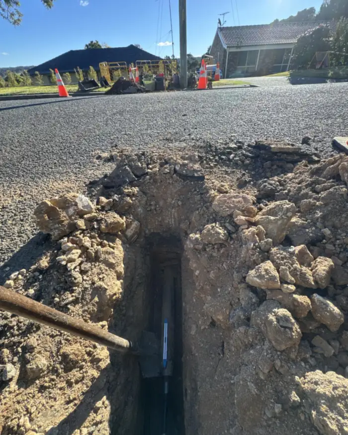 Service trench across a road with the new pipe at the bottom