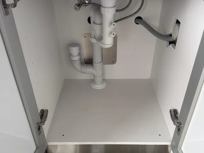 Tidy under-sink plumbing: trap, stop taps and dishwasher connection