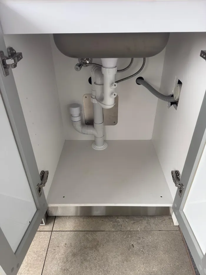 Tidy under-sink plumbing: trap, stop taps and dishwasher connection